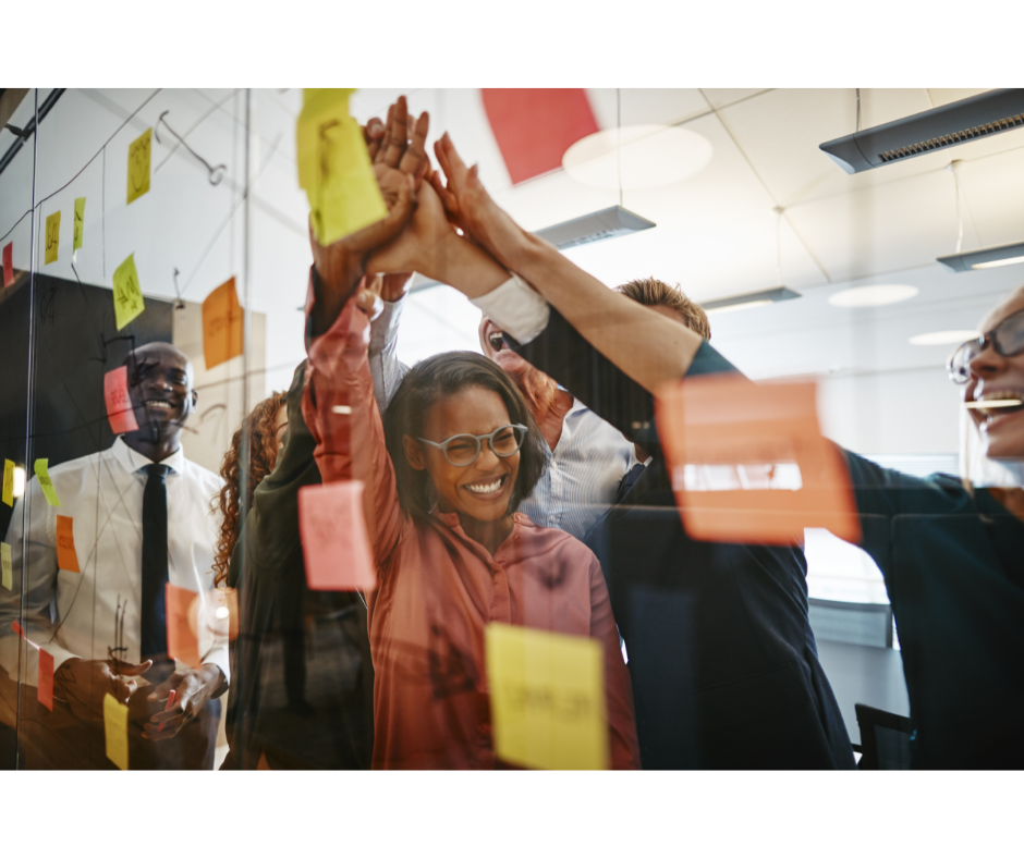 Happy employees giving each other a high five after a brainstorming session.