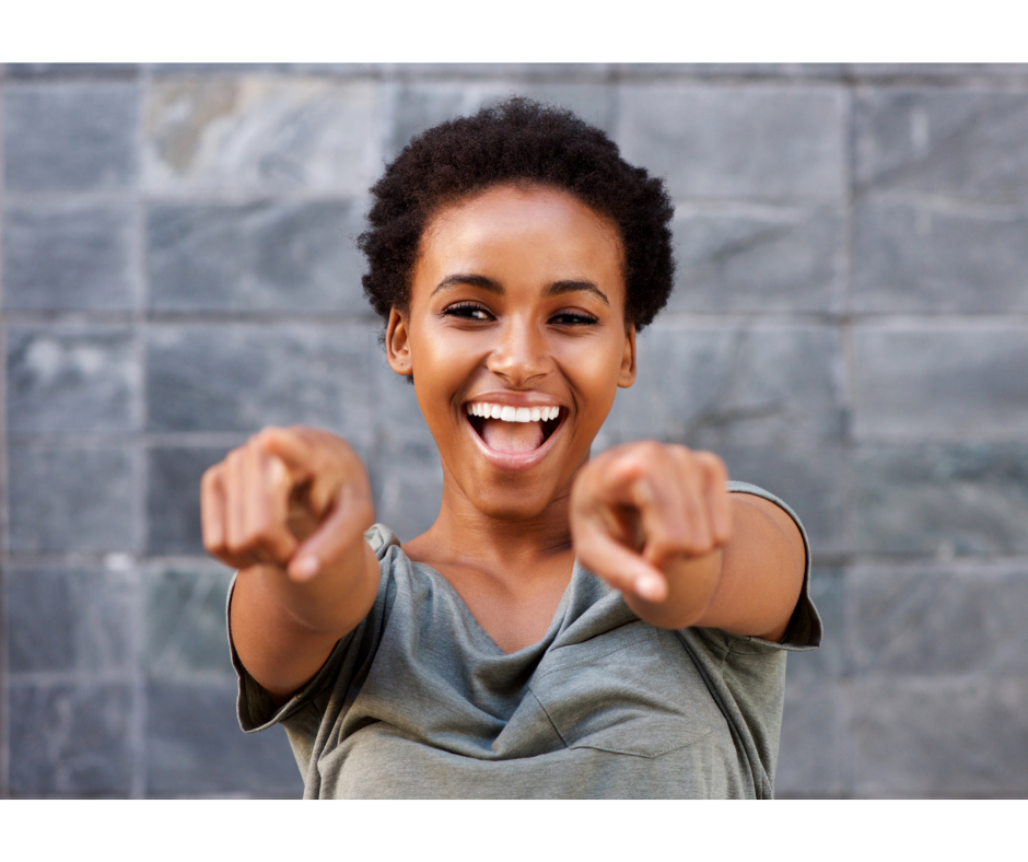 Happy female leader pointing into the camera.